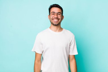 young handsome hicpanic man looking happy and goofy with a broad, fun, loony smile and eyes wide open