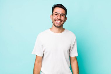 young handsome hicpanic man with a big, friendly, carefree smile, looking positive, relaxed and happy, chilling