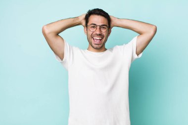 young handsome hicpanic man looking happy, carefree, friendly and relaxed enjoying life and success, with a positive attitude