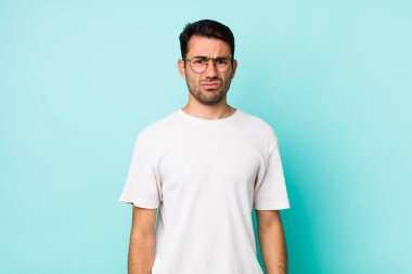 young handsome hicpanic man feeling sad and whiney with an unhappy look, crying with a negative and frustrated attitude