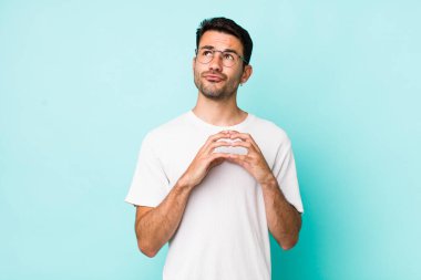 young handsome hicpanic man scheming and conspiring, thinking devious tricks and cheats, cunning and betraying