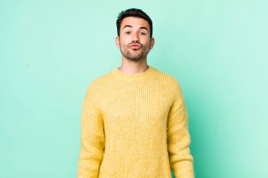 young handsome hicpanic man pressing lips together with a cute, fun, happy, lovely expression, sending a kiss