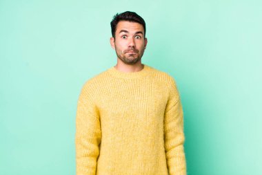 young handsome hicpanic man feeling sad and stressed, upset because of a bad surprise, with a negative, anxious look