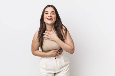 Genç ve güzel bir kadın komik bir şakaya yüksek sesle gülüyor, mutlu ve neşeli hissediyor, eğleniyor.