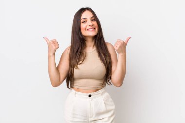 Genç ve güzel bir kadın neşeyle gülümsüyor ve mutlu görünüyor, kaygısız ve pozitif hissediyor.