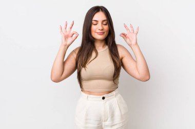 Genç ve güzel bir kadın konsantre olmuş ve meditasyon yapıyor, tatmin olmuş ve rahatlamış hissediyor, düşünüyor ya da bir seçim yapıyor.