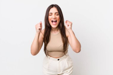 Genç, güzel bir kadın sinirli, sinirli, kızgın bakışlar ve sıkı yumruklar ile agresif bir şekilde bağırıyor.