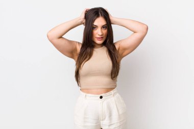 Genç, güzel bir kadın kendini stresli, endişeli, endişeli ya da korkmuş hissediyor. Elleri başının üstünde, hatayla panikliyor.