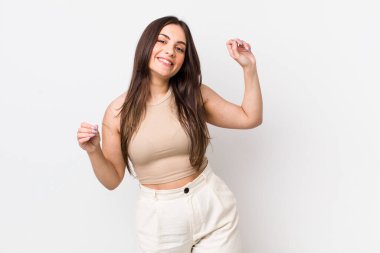 Genç, güzel bir kadın gülümsüyor, kaygısız hissediyor, rahat ve mutlu, dans ediyor ve müzik dinliyor, bir partide eğleniyor.