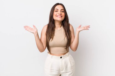 Genç, güzel bir kadın mutlu, heyecanlı, şaşırmış ya da şaşırmış hissediyor. İnanılmaz bir şeye gülümsüyor ve hayrete düşüyor.