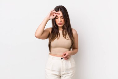 Genç ve güzel bir kadın stresli görünüyor, yorgun ve hayal kırıklığına uğramış, alnından ter damlıyor, umutsuz ve bitkin hissediyor.