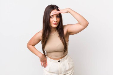 Genç, güzel bir kadın şaşkınlık ve şaşkınlık içinde bakıyor. Alnı açık, uzaklara bakıyor, izliyor ya da arıyor.