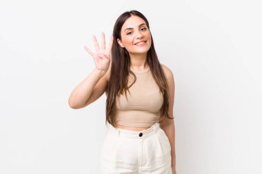 Genç, güzel bir kadın gülümsüyor ve arkadaş canlısı görünüyor. Dört ya da dört numarayı gösteriyor. Elleri önde, geri sayıyor.