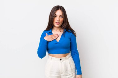 Genç ve güzel bir kadın şok olmuş, şaşırmış ve şaşırmış hissediyor, elleri göğsünde ve ağzı açık, kim olduğunu söylüyor, ben mi??