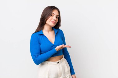 Genç, güzel bir kadın neşeyle gülümsüyor, mutlu hissediyor ve fotokopi alanında bir konsept gösteriyor.