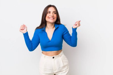 Genç ve güzel bir kadın son derece mutlu ve şaşırmış görünüyor, başarıyı kutluyor, bağırıyor ve zıplıyor.