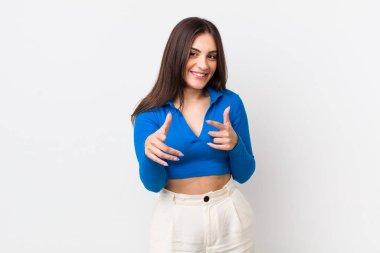 Genç, güzel bir kadın kendini mutlu, havalı, tatmin olmuş, rahat ve başarılı hissediyor, kameraya bakıyor, seni seçiyor.