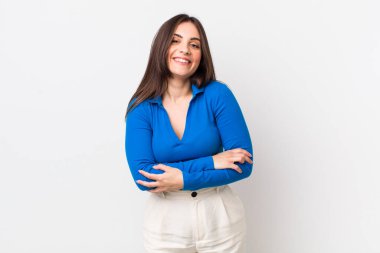 Genç, güzel bir kadın mutlu, gururlu ve tatmin olmuş görünüyor. Kollarını kavuşturup gülümsüyor.