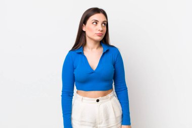 Genç ve güzel bir kadın kafası karışmış görünüyor, merak ediyor veya bir sorunu çözmeye çalışıyor ya da düşünüyor.