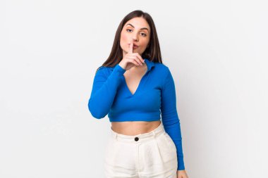Genç ve güzel bir kadın sessizlik ve sessizlik istiyor, parmaklarıyla ağzının önünde işaret ediyor, 