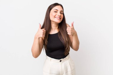 Genç ve güzel bir kadın gülümseyerek mutlu, pozitif, kendinden emin ve başarılı görünüyor.