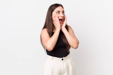 Genç, güzel bir kadın mutlu, heyecanlı ve şaşırmış hissediyor. İki eli de havada bir tarafa bakıyor.