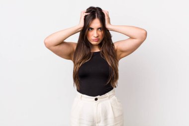 Genç ve güzel bir kadın stresli ve hayal kırıklığına uğramış hissediyor, elele tutuşuyor, yorgun, mutsuz ve migren ağrısı çekiyor.