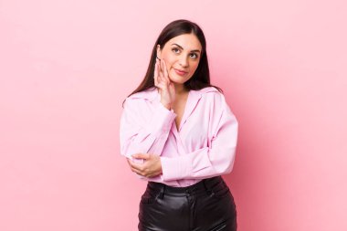 Genç ve güzel bir kadın mutlu bir şekilde gülümsüyor ve hayal kuruyor ya da şüphe ediyor.