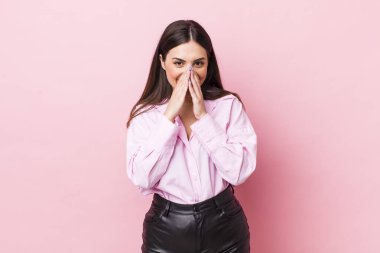 Genç ve güzel bir kadın mutlu, neşeli, şanslı ve şaşkın görünüyor. İki eliyle ağzını kapatıyor.