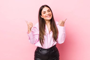 Genç ve güzel bir kadın neşeyle gülümsüyor ve mutlu görünüyor, kaygısız ve pozitif hissediyor.