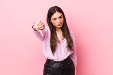 Genç, güzel bir kadın kızgın, sinirli, hayal kırıklığına uğramış ya da hoşnutsuz, ciddi bir bakışla başparmağını kaldırıyor.