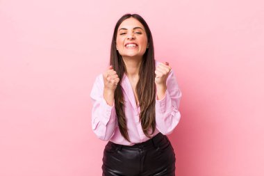 Genç, güzel bir kadın sinirli, sinirli, kızgın bakışlar ve sıkı yumruklar ile agresif bir şekilde bağırıyor.