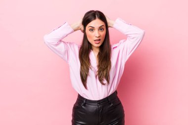 Genç, güzel bir kadın kendini stresli, endişeli, endişeli ya da korkmuş hissediyor. Elleri başının üstünde, hatayla panikliyor.