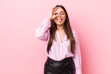 Genç ve güzel bir kadın mutlu bir şekilde gülümsüyor, şaka yapıyor ve gözetleme deliğinden bakıyor, sırları gözetliyor.