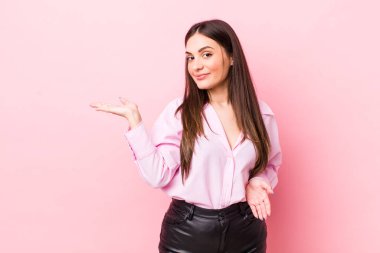 Genç, güzel bir kadın gülümsüyor, kendinden emin, başarılı ve mutlu hissediyor, fotokopi alanında fikir veya konsept gösteriyor.