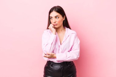 Genç ve güzel bir kadın ciddi, düşünceli ve endişeli, elleri çenesine bastırılmış bir şekilde yan bakıyor.