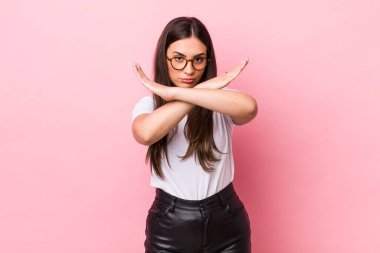 Genç ve güzel bir kadın senin bu tavırlarından rahatsız ve bıkkın görünüyor. Yeter artık! Eller önde çapraz, durmanı söylüyor.