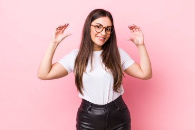 Genç, güzel bir kadın iki eliyle kendi gülüşünü çiziyor, olumlu ve mutlu görünüyor, sağIık kavramı.