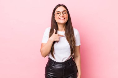 Genç, güzel bir kadın mutlu, gururlu ve şaşırmış görünüyor, neşeli bir şekilde kendini gösteriyor, kendinden emin ve kibirli hissediyor.