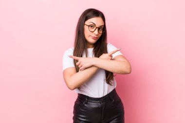 Kafası karışmış, güvensiz ve şüpheyle zıt yönlere bakan güzel bir kadın.