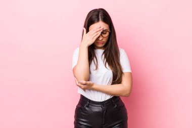 Genç, güzel bir kadın stresli, utanmış ya da üzgün görünüyor. Baş ağrısı var, yüzü elle kapatılmış.