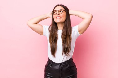 Genç ve güzel bir kadın gülümsüyor ve rahatlıyor, tatmin oluyor ve kaygısız, neşeli ve rahatlatıcı.