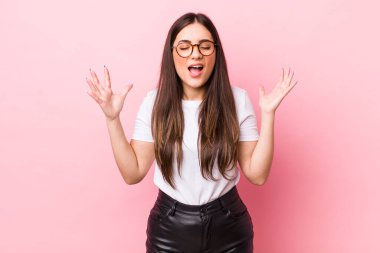 Genç ve güzel bir kadın öfkeyle bağırıyor, stresli hissediyor ve ellerini havaya kaldırıp neden ben diye bağırıyor.