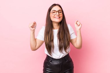 Genç ve güzel bir kadın mutlu, şaşırmış ve gururlanmış hissediyor, bağırıyor ve başarıyı büyük bir gülümsemeyle kutluyor.