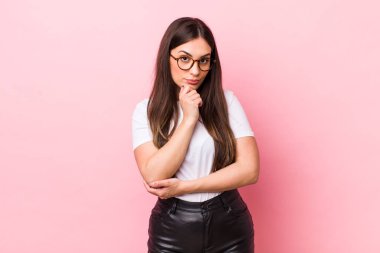 Genç, güzel bir kadın ciddi görünüyor, kafası karışık, kararsız ve düşünceli, seçenekler ve seçimler arasında şüpheci.