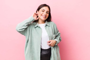 Genç, güzel bir kadın neşeli ve kendinden emin bir şekilde gülüyor. Sıradan, mutlu, dostane bir gülümsemeyle.