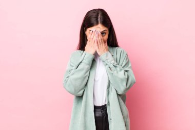 Genç, güzel bir kadın korkmuş ya da utanmış hissediyor. Gözleri yarı kapalı ya da ellerle dikizliyor.