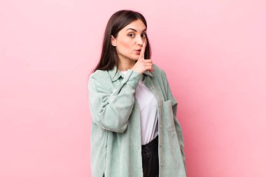 Genç ve güzel bir kadın sessizlik ve sessizlik istiyor, parmaklarıyla ağzının önünde işaret ediyor, 