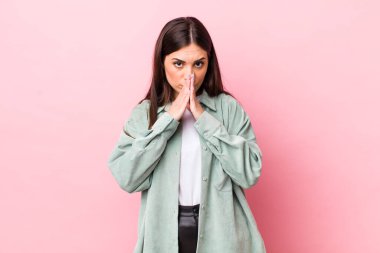 Genç, güzel bir kadın endişeli, üzgün ve korkmuş hissediyor. Ağzını ellerle kapatıyor. Endişeli ve berbat görünüyor.