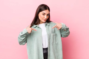 Genç ve güzel bir kadın gururlu, pozitif ve iki eliyle göğsünü gösteren